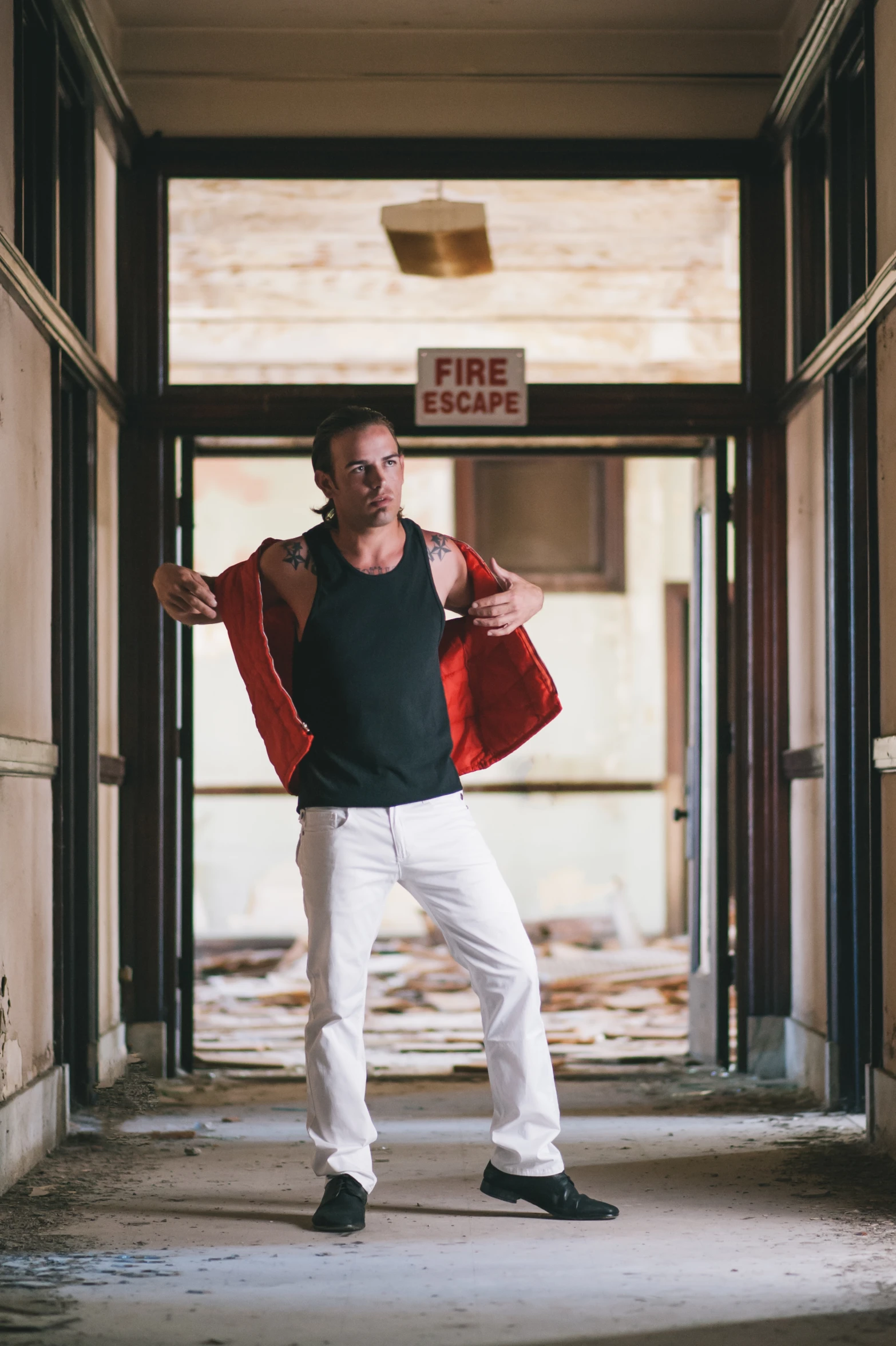 a man in white pants and black shirt posing for the camera