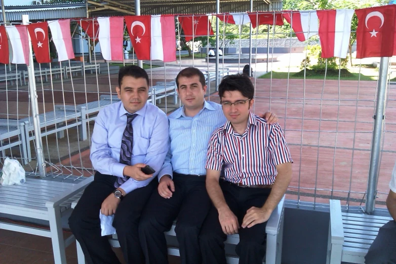 a group of three men sitting next to each other