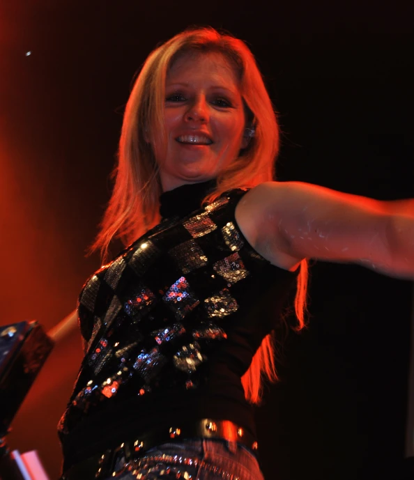 a woman with blonde hair standing in front of a microphone