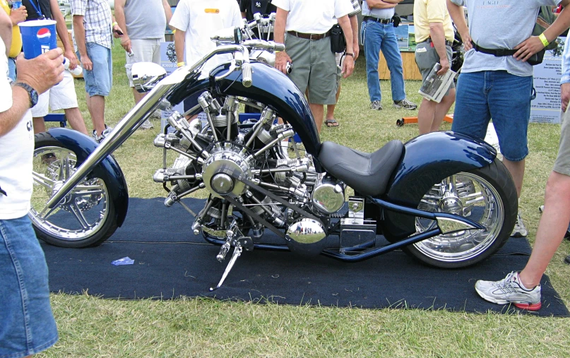 a close up of a motorcycle with people standing around