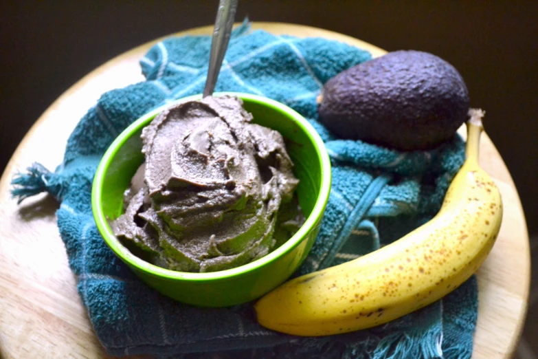 an avocado and a cup of chocolate ding on a blue towel