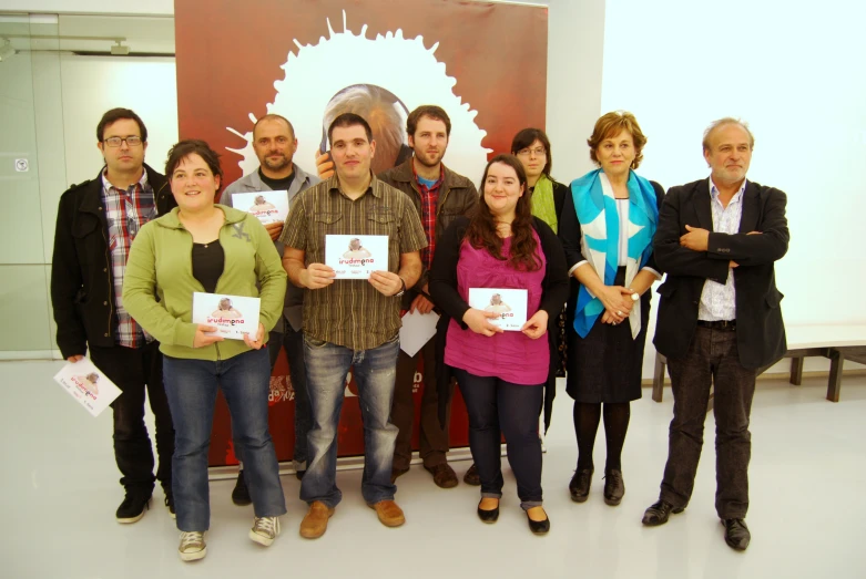 a group of people holding paper signs with artwork behind them