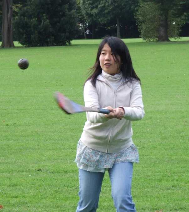 a woman holding a tennis racquet as if to swing at a ball