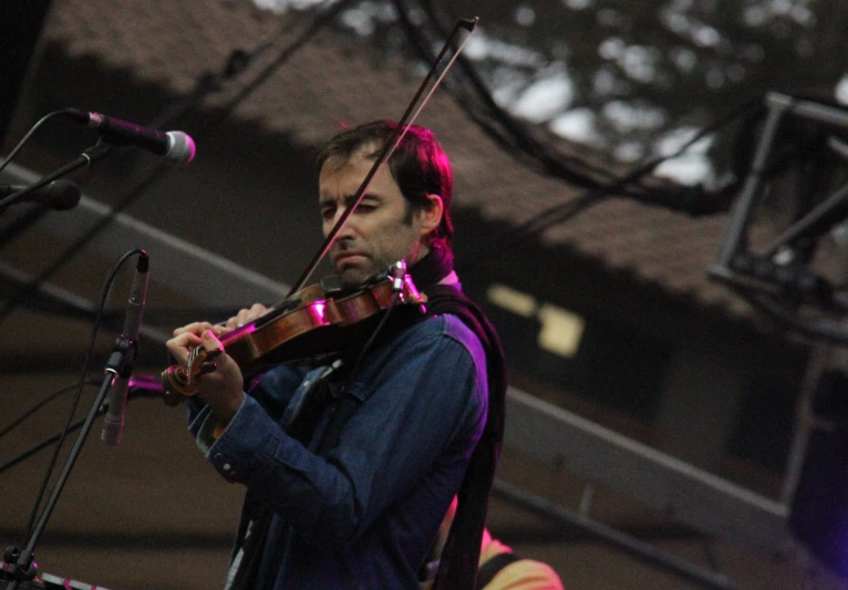a man with a violin performing at an outdoor concert