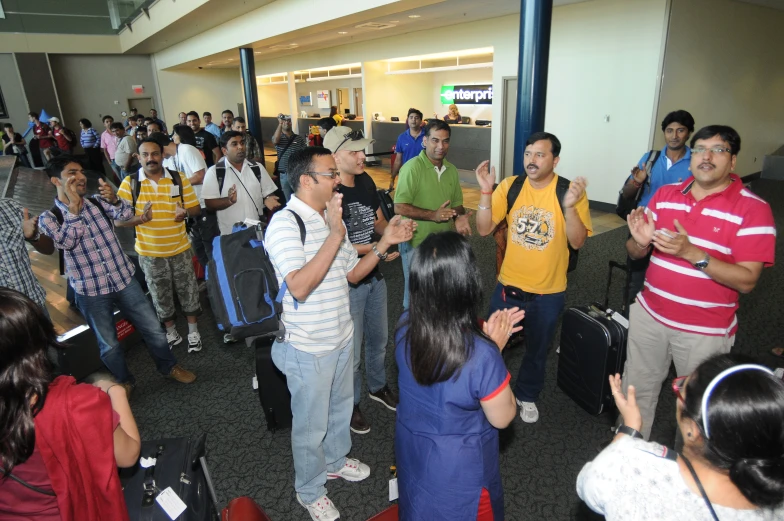 people standing in a lobby next to luggage