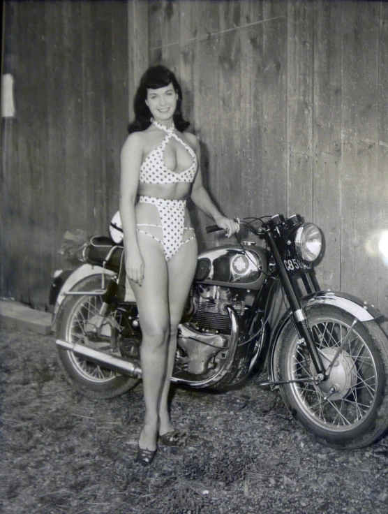 a very cute lady in a bathing suit by a motorcycle