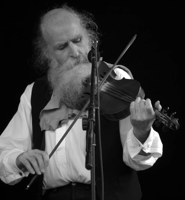 a man with a beard plays an violin on stage