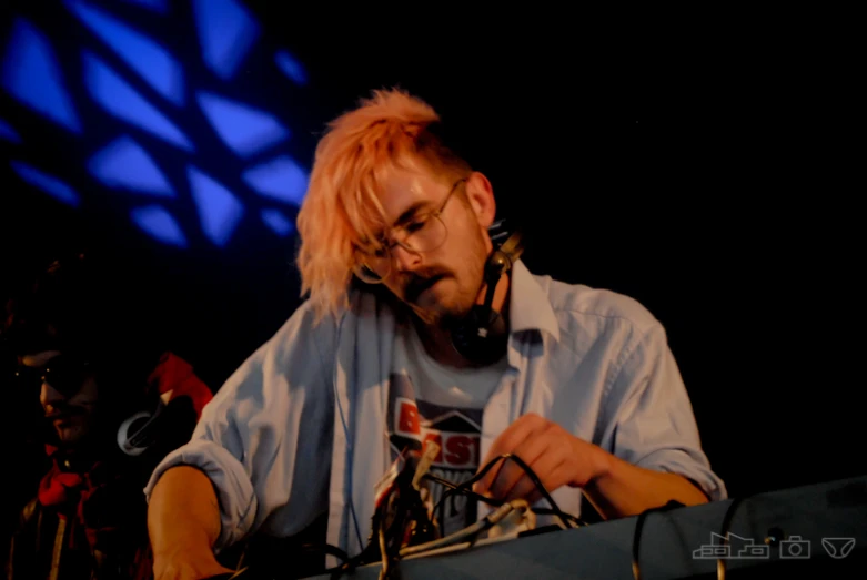 a man in white shirt sitting in front of a microphone