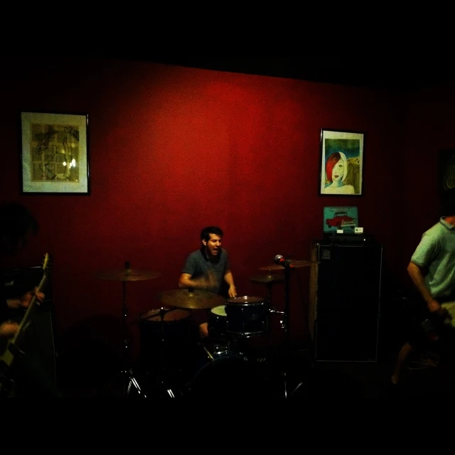 band members performing with red walls in room