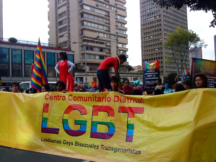 men and women holding flags in a gay pride parade