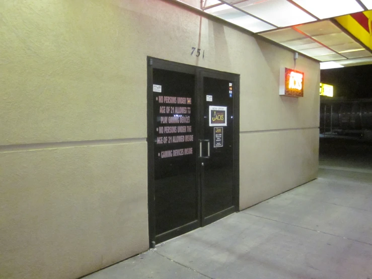an entrance to a building with two black doors