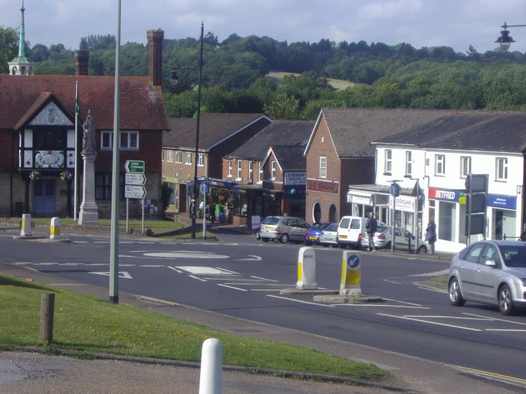 there are several cars at the intersection of this town