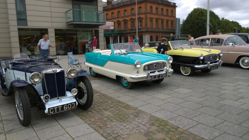 a number of cars parked on a brick road