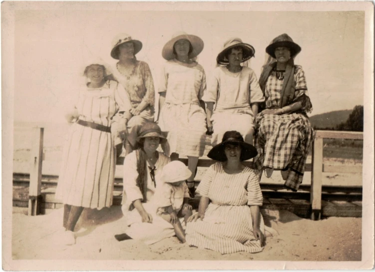 a group of women sitting around each other on a beach