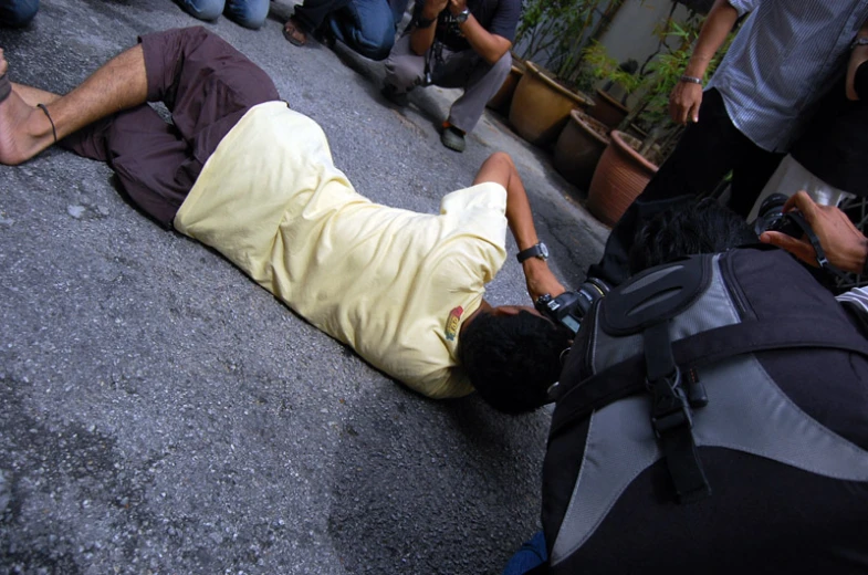 a man lying on the ground holding a camera in his hand