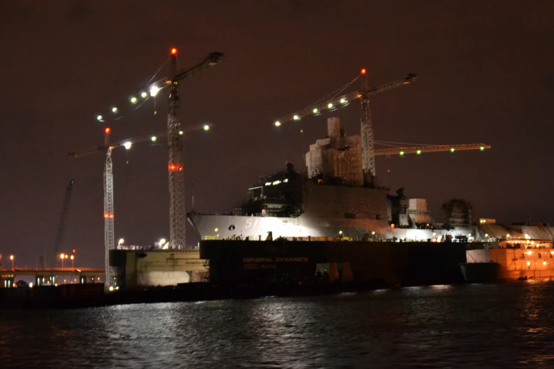 a large cargo ship is anchored near crane's lights