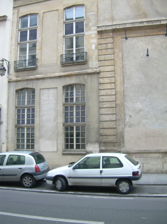 two parked cars sit on the side of a road