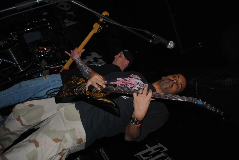 a man with an arm tattoo and guitar playing