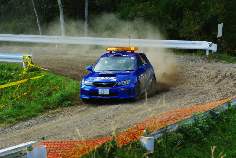 a car with its lights on drives through mud