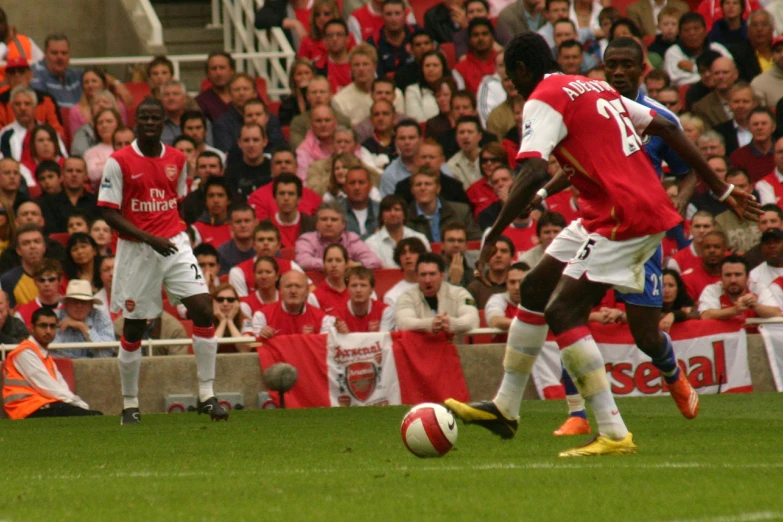 two soccer players fighting for the ball in front of spectators