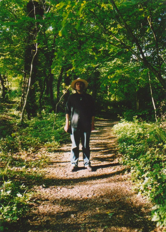 a man walking on the dirt path in the forest