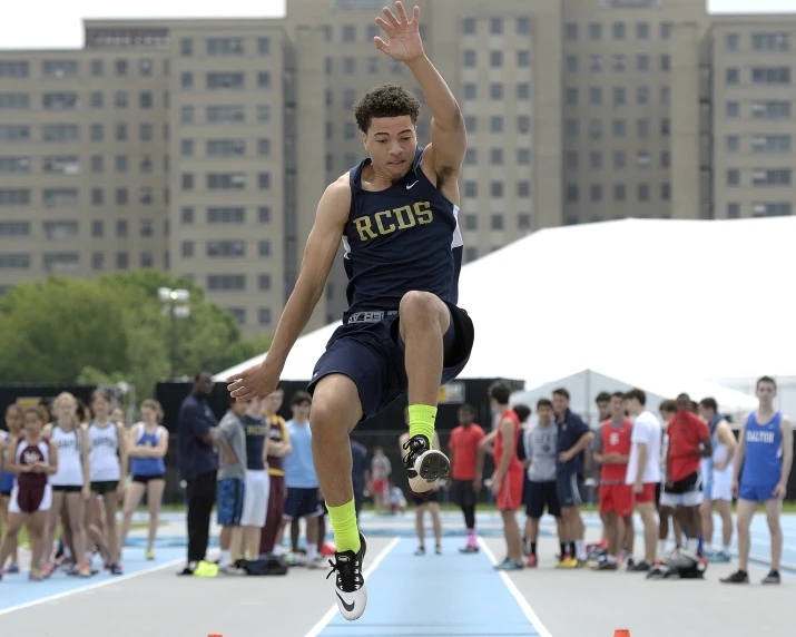 a male athlete is leaping up in the air