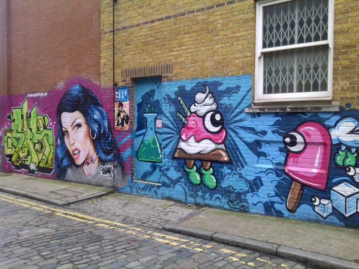 several street art pieces of blue, pink, and purple with faces on them