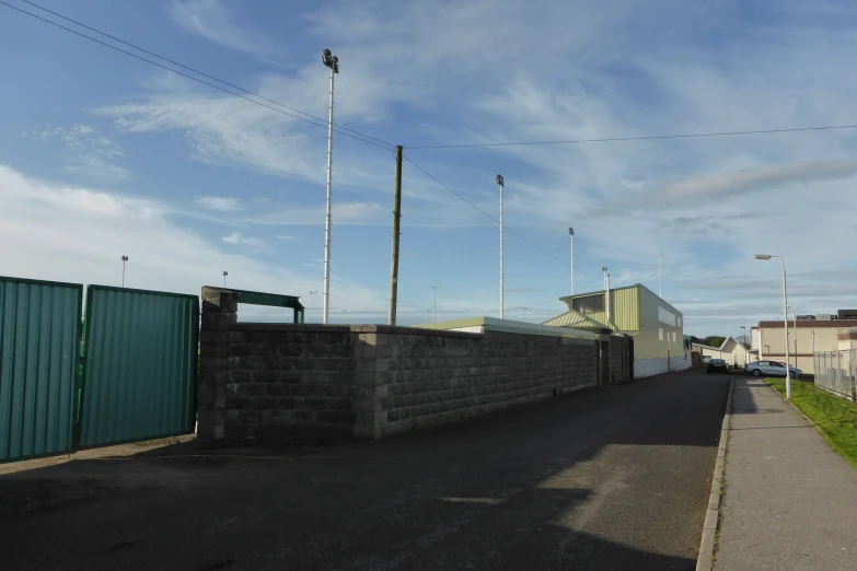 a street is blocked off from traffic by a green fence