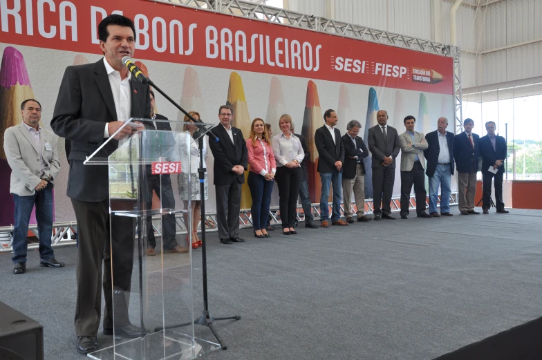 man at podium during rally in front of an audience