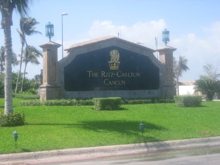 an entrance sign in a lush green area