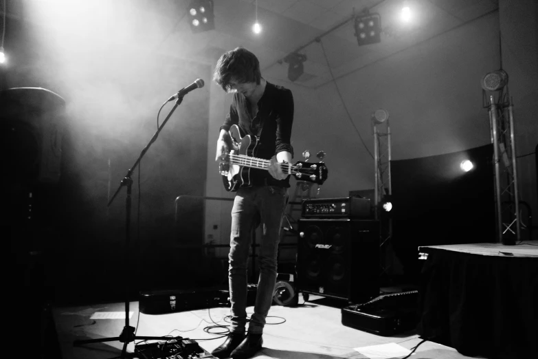 a male in black shirt playing on a bass