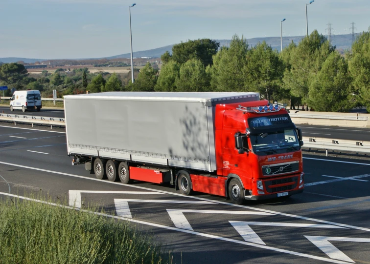 a red semi truck driving down the highway