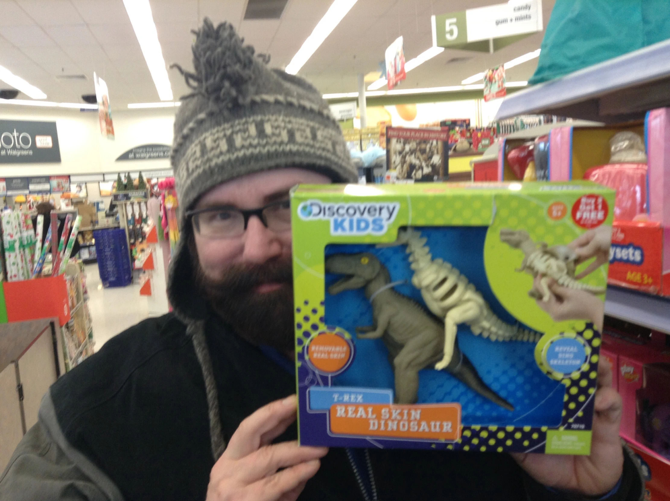 man in grey hat looking at dinosaur in box