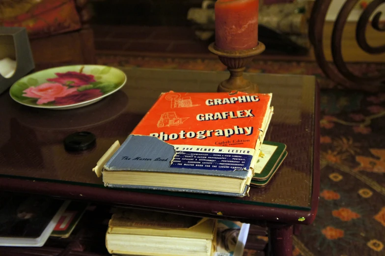 a table with books, a plate and candles