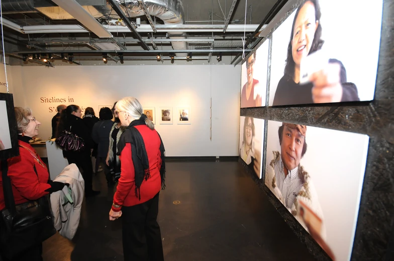 a group of people in an art museum viewing some pictures