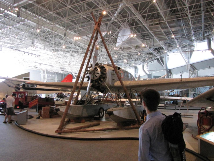 people looking at an old plane with a ladder on top