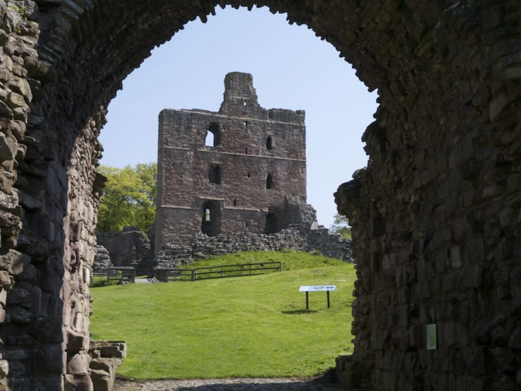 an arch leads to a view of a ruined building