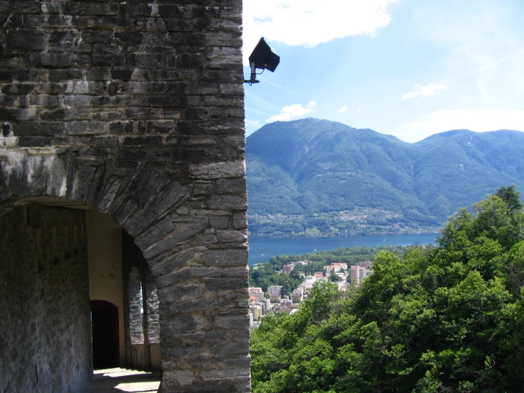 a brick building in front of a mountain range with mountains