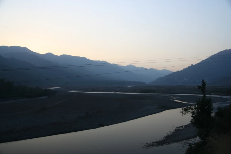 the river is surrounded by the mountains on a clear day