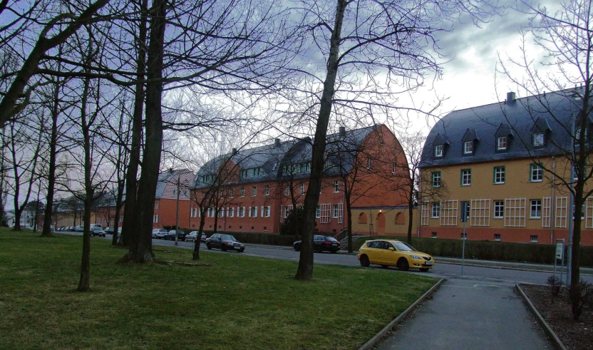 some cars on a road near a large building