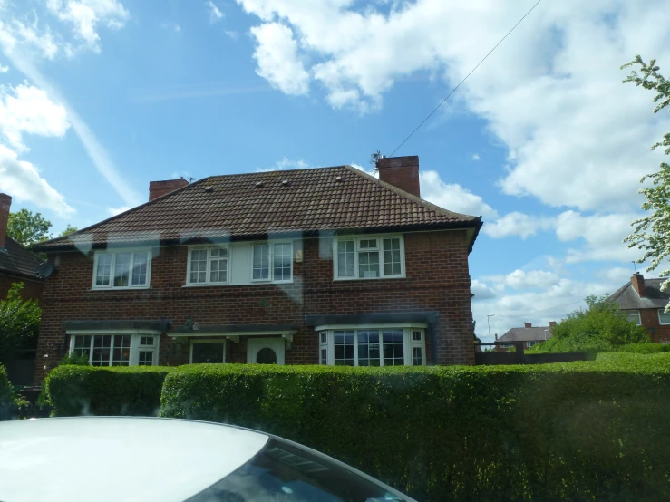 an old red brick house that is standing near some trees