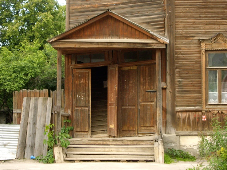 old wooden house with some windows and steps up