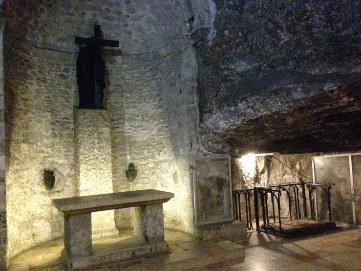 a bench is on a tiled floor in front of a stone wall