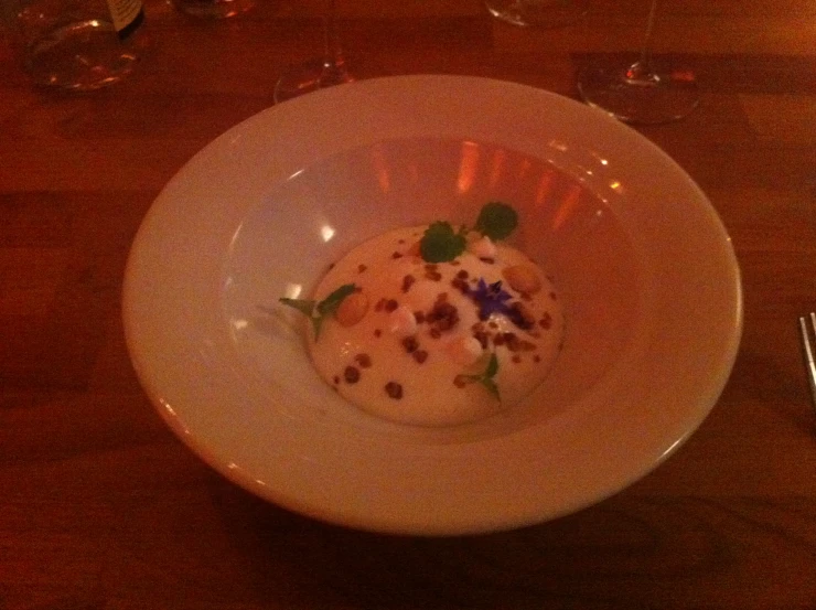 a plate with a spoon next to it and wine glasses