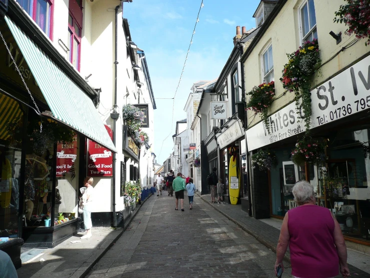 people walking on a street with shop fronts