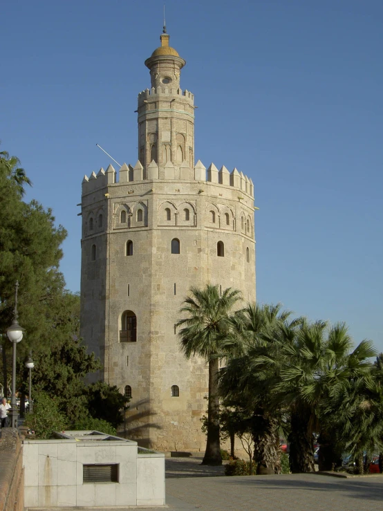 the large tower is situated next to trees and a light pole