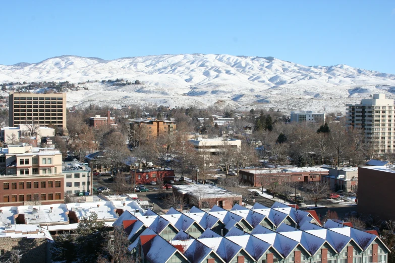 the view of a city, with snow covered mountains behind