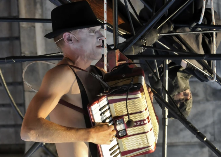 a man wearing a top hat with an accordion