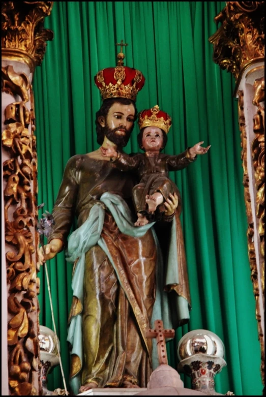 a statue of a man with a beard and a woman dressed in a crown