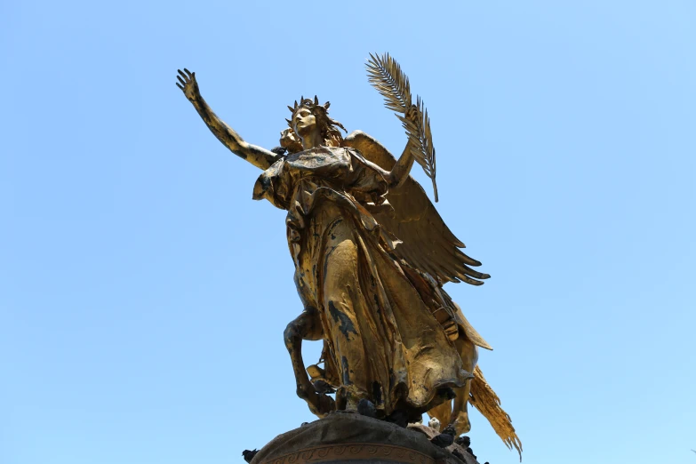 a very tall golden angel statue on top of a building